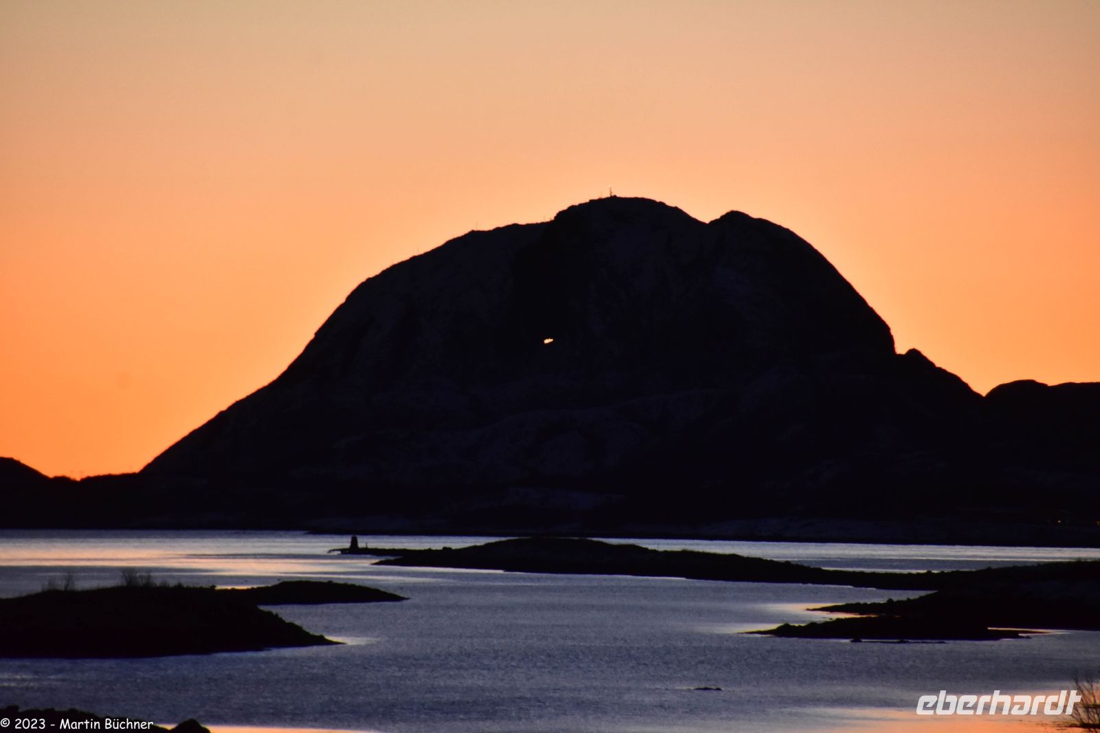 Brønnøysund - UNESCO Geopark Trollfjell - Torghatten - Magischer Berg (Hut) mit dem Loch - in der Bildmitte leuchtet die Sonne durch das Loch