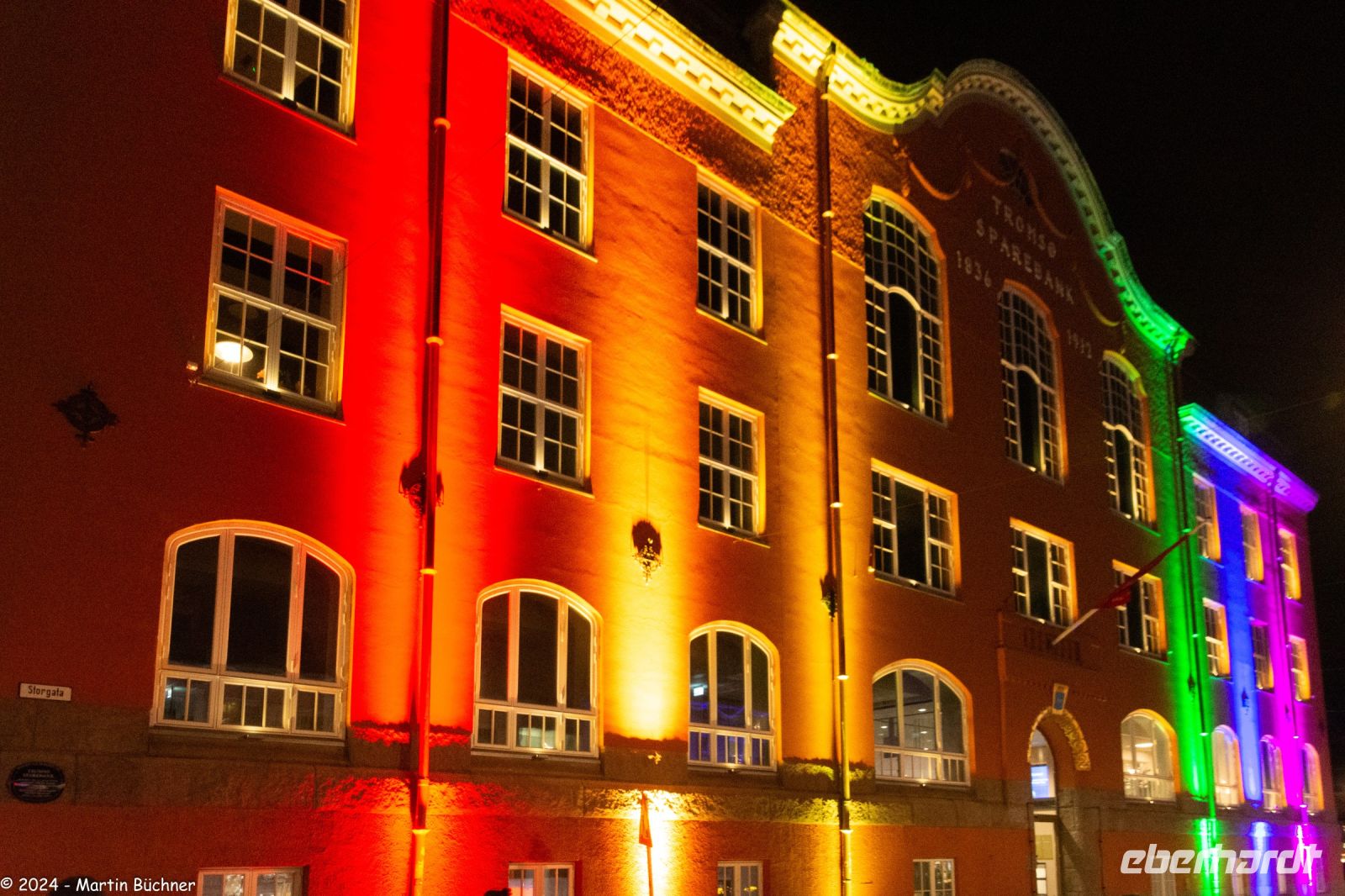 Tromsø - Gebäude leuchtet in den Farben der Samischen Flagge