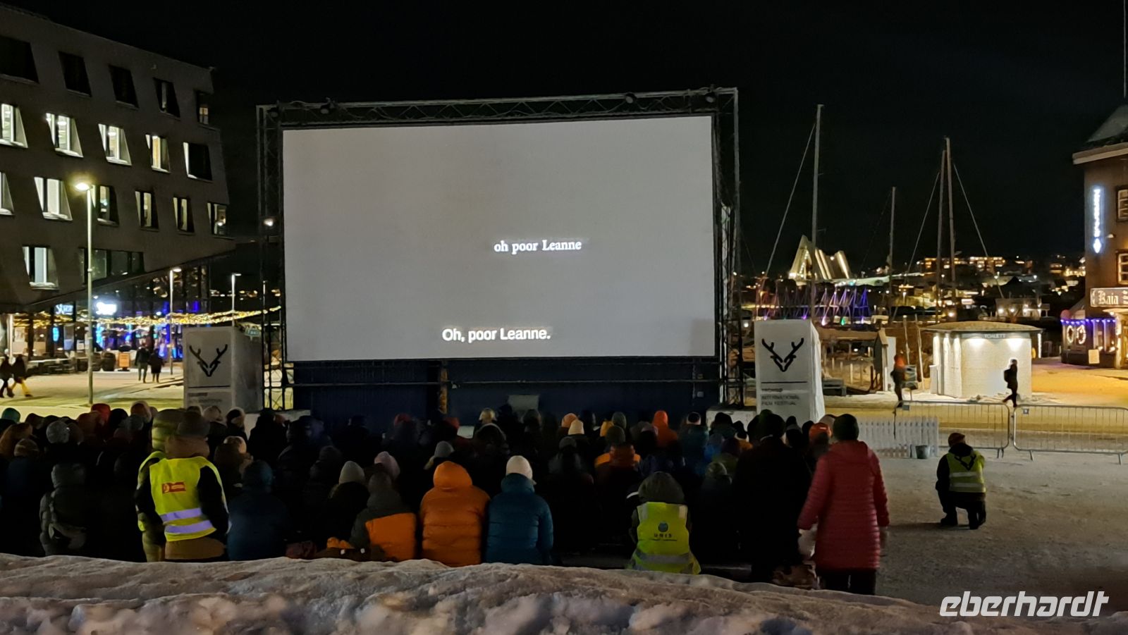Tromsø - Friluftsliv - Freiluftleben - Filmfestival mitten im Winter auf dem Hauptplatz auf Rentierfellen sitzend