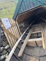 ein Fischer zeigt ein altes Ruderboot aus Elduvik