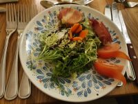 Gegrillter Ziegenkäse im Speckmantel auf grünem Salat mit Balsamicoglace