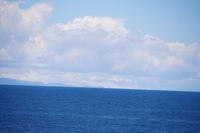 Sieht man genau hin, sieht man zwischen Wolken und See die schneebedeckten Berge der Königskordillere