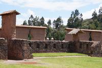 Durch die den Wirakocha-Tempel längs in zwei Hälften teilende Mauer die Kirchturmspitzen des modernen Raqchi