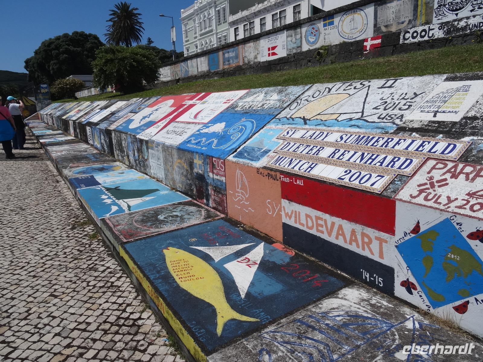 Rundgang durch Horta - Gemälde der Segler an der Mauer des Jachthafens