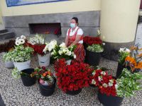 Blumenverkäuferin in Tracht vor der Markthalle
