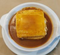 Francesinha, ein portugiesisches Sandwich aus Toast, Kochschinken, Linguioca und geschmolzenem Käse in scharfer Sauce