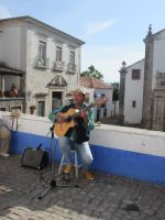 ein Sänger verdient sich in Obidos ein Zubrot