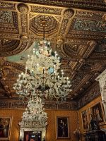 Prachtvolle Deckenverzierungen und imposante Leuchter im Schloß Peles