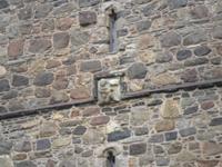 Teufelsdarstellung am Turm der Kirche von Roghadal, Insel Harris