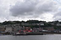 023 Oban, Blick vom Hafen auf die Stadt mit Distillery und Mc Caigs Tower