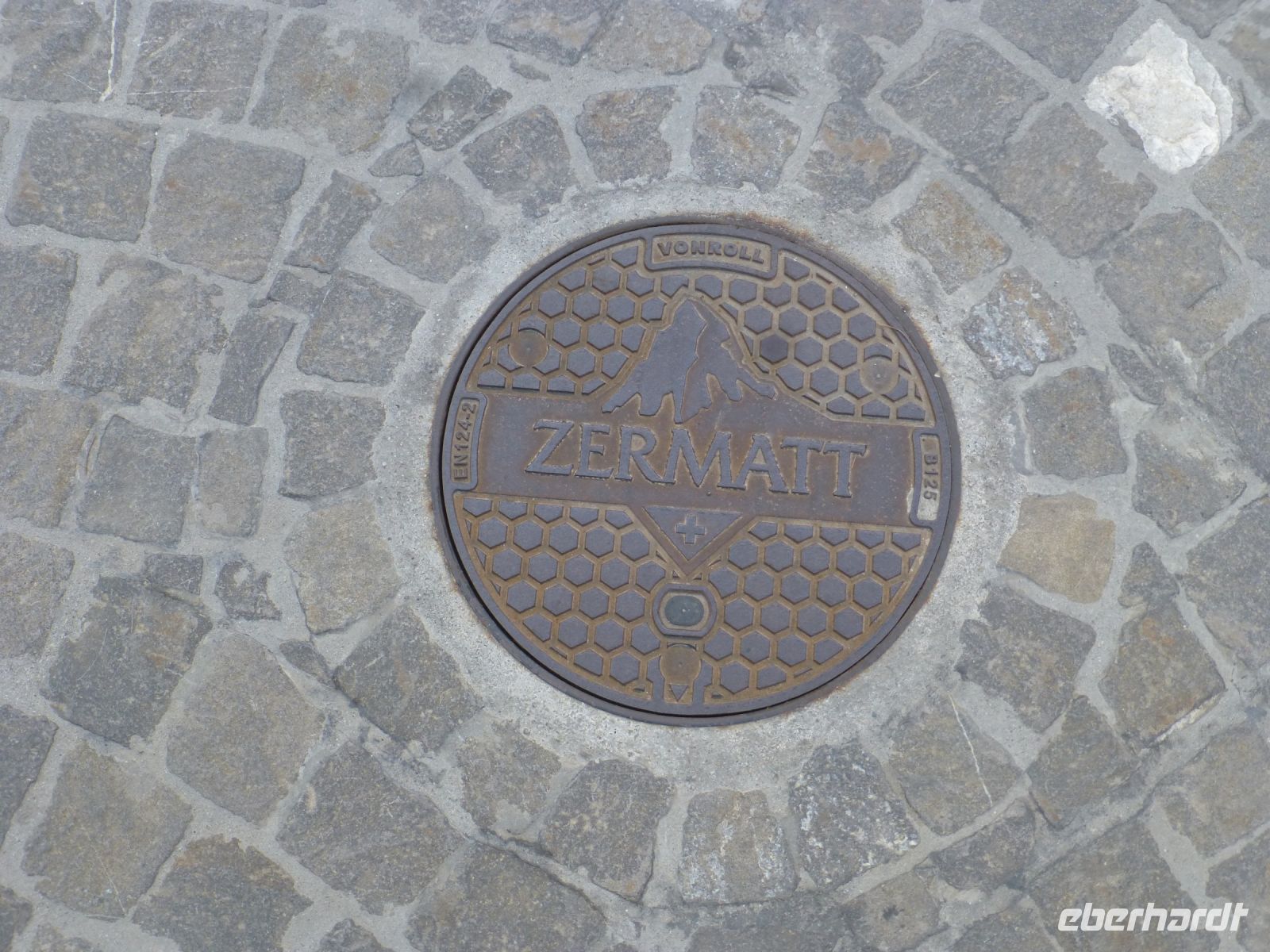 Auch der Kanaldeckel trägt das Markenzeichen.