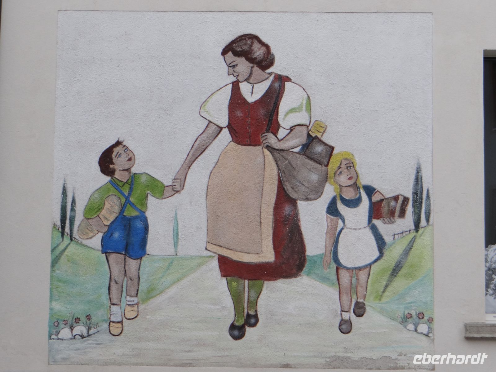 Tiefencastel, das Wandbild zeigt die Mutter und ihre beiden Kinder beim Einkaufen. Die Landschaft ist eher italienisch als schweizerisch.