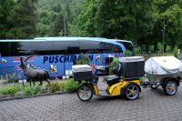 Postauto und Reisebus vor dem Hotel