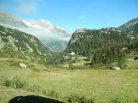 Schneebedeckte Spitzen vor grüner Umgebung.