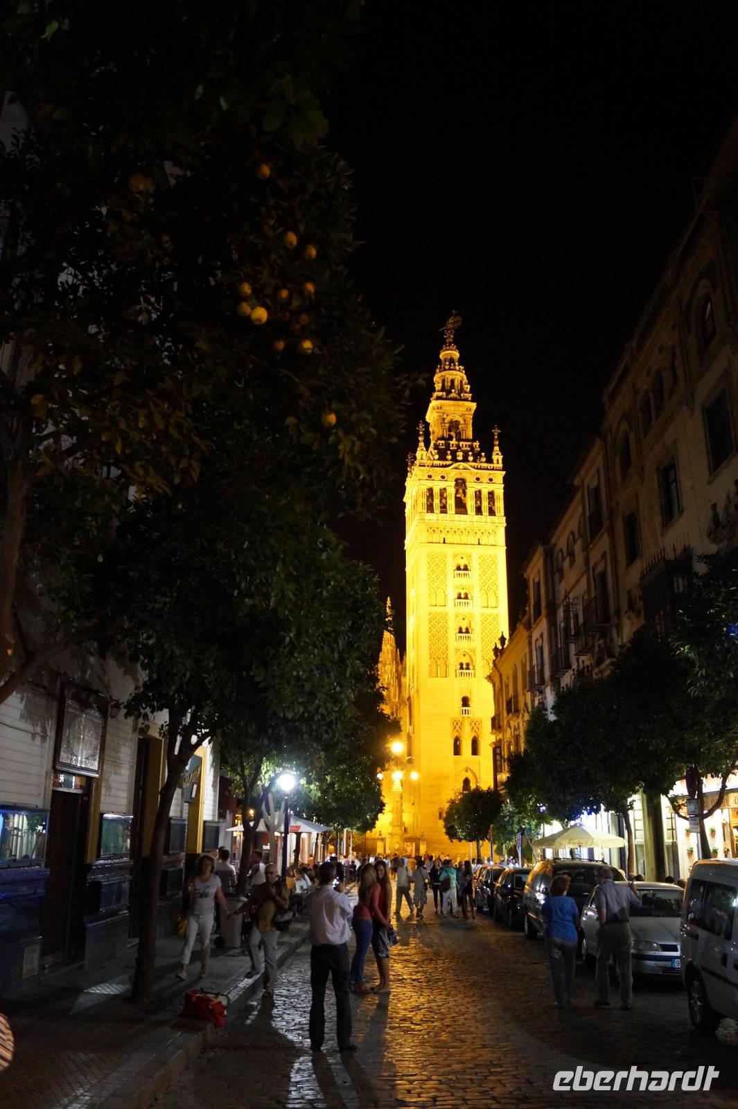 Giralda und Straßenleben in Sevilla bei Nacht