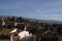 Der Albaicín vom Mirador San Cristobal aus gesehen. Vorne die Stadtmauer aus dem 11. Jhdt. und (Bildmitte rechts) der Palast der Mutter des letzten Sultans, im Hintergrund die Sierra Nevada. Dazwischen die Alhambra. 