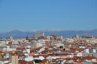 Dachterrasse - Ausblick aufs Stadtpanorama mit schneebedeckten Bergen im Hintergrund