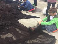 Frauen flicken die Fischernetze