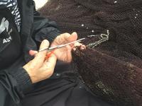 Frauen flicken die Fischernetze