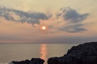 Wanderreise Menorca - Sonnenuntergang in Cala Blanca - In der Luft die Asche des La Palma Vulkans - Blick nach Mallorca