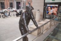 Ein Passant sinniert in Bronze gegossen über archäologischen Resten Alt-Madrids