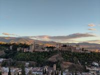 Die Alhambra und die vom Licht der untergehenden Sonne angestrahlten Ausläufer der Sierra Nevada dahinter