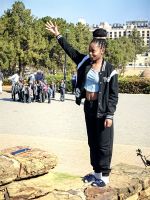 Eine junge Frau läßt sich am Nelson Mandela Denkmal in Pretoria fotografieren