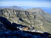 Ein Klippschliefer relaxt auf dem Tafelberg vor dem Panorama