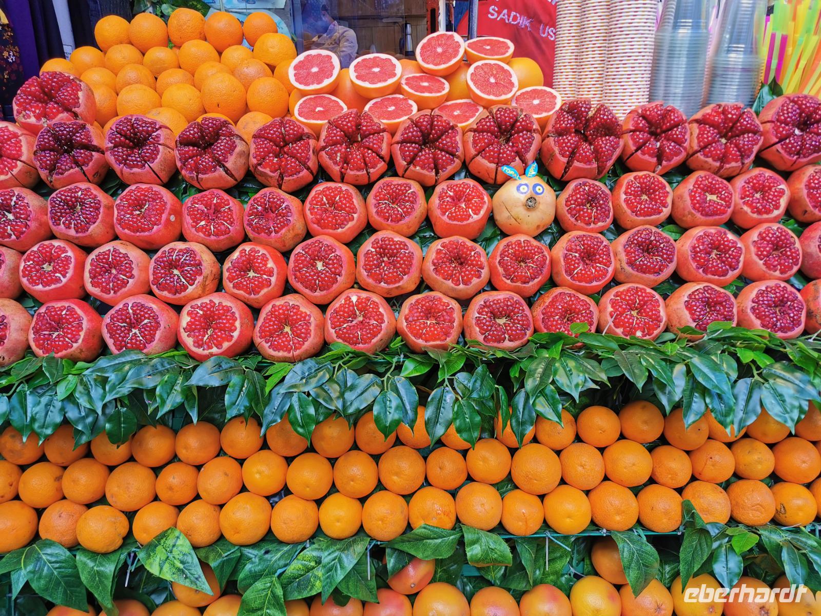Herrlich drapierte Granatäpfel und Orangen an einem Saftstand