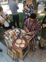 Kalligraphie-Künstler bei der Arbeit im Hof der Ulug-Bek-Medrese, Registan-Platz in Samarkand