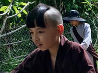 Junger Moench radelt zurueck zum Kloster