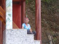 Eine Oma posiert vor einem vornehmen Haus.