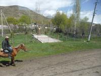 Unterwegs: Blick aus dem Fenster des Busses - Kirgise auf dem Pferd