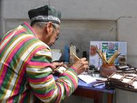 Kalligraphie-Künstler bei der Arbeit, im Hof der Ulugbek-Medresse, Registan in Samarkand