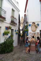 Blumengasse Córdoba mit dem Turm der Kathedale und drei spanischen Grazien