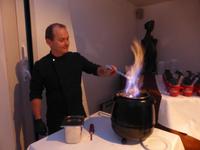 Der Hotelchef beim Zubereiten der Feuerzangenbowle.
