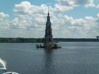 Überflutetes Dorf mit berühmten Kirchturm während der Schifffahrt