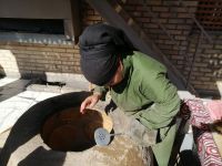 Stadtrundgang durch Chiwa, eine Frau beim Brotbacken