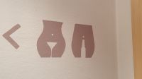 Weinglas und Weinflasche weisen den Weg zum WC
