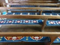 Die Sitzbänke der Kirche sind mit den 40 verschiedenen Wappen der Pachtgrundstücke bestickt. So hat jeder seinen festen Platz.