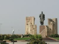Amir Timur Denkmal in Schachrisabs, im Hintergrund - die Ruinen des Ak Saray