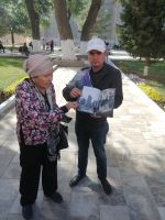 Barno erzählt uns die Geschichte der Bibi-Hanim-Moschee anhand von Fotos eines Händlers, Samarkand