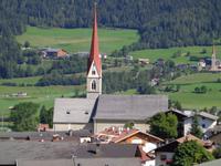 Dorfkirche von Stilfes, im Hintergrund die Wallfahrtskirche Maria Trens