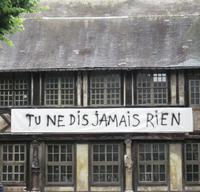 In Rouen, Aître St. Maclou mit Ausstellungsplakat (Übers.: Nie sagst du was)