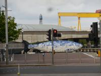 Der blaue Fisch für sauberes Gewässer in Belfast, dahinter ein H&W-Kran der Fa. Krupp